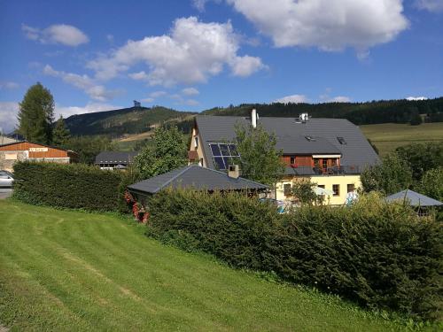 a house on a hill with a green field at Family apartments V Zátiší in Dolní Morava