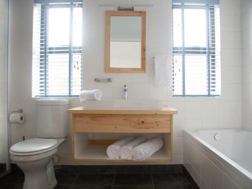 a bathroom with a sink and a toilet and a tub at 7 Ackermann Place Guest House in Stellenbosch