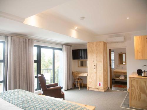 a bedroom with a bed and a desk in a room at 7 Ackermann Place Guest House in Stellenbosch