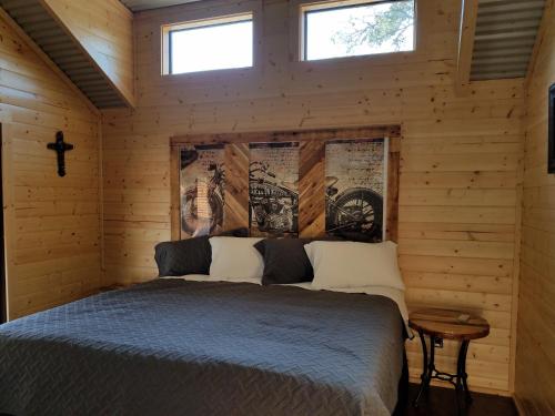 a bedroom with a bed in a wooden cabin at Al's Hideaway Cabin and RV Space, LLC in Pipe Creek