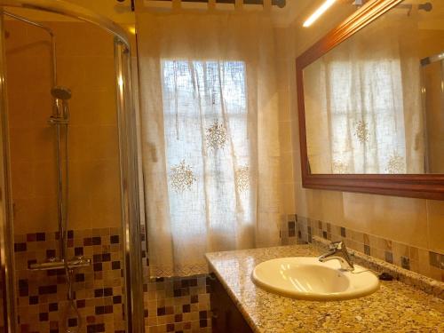 a bathroom with a sink and a shower and a mirror at Costa Este House in Monte de Breña