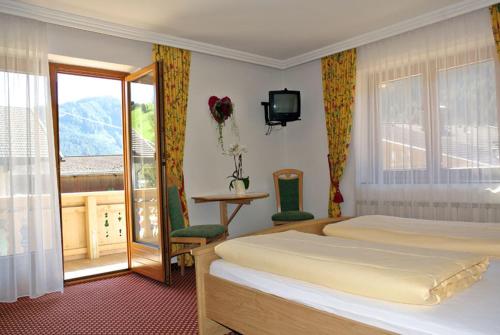 a hotel room with two beds and a balcony at Villa Sonne Gerlos - only room in Gerlos