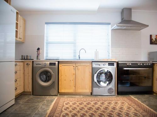a kitchen with a washing machine and a washer at 7 Ackermann Place Guest House in Stellenbosch