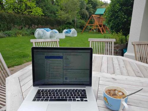 a laptop computer sitting on a table with a cup of coffee at Makepeace Place Homestay in Hamilton