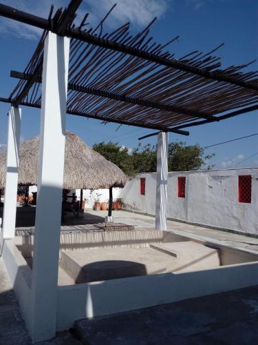 a pavilion with a straw umbrella and a table at Galerazambahostal in Galerazamba