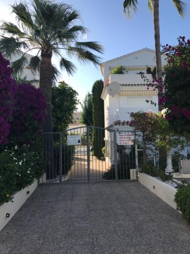 a gate in front of a building with a palm tree at Oasis Paradise in Denia