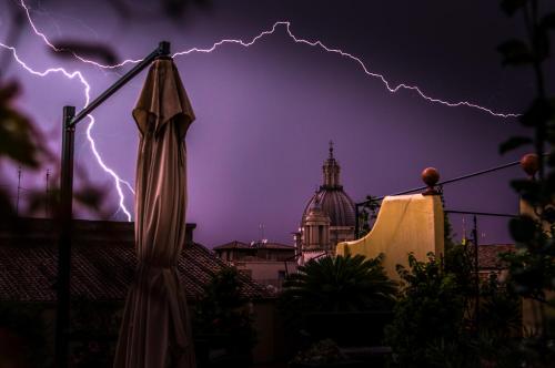 a lightning storm over a city with a umbrella at Sant'Ivo Apartments in Rome