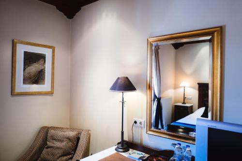 a hotel room with a bed and a mirror at Trikolonion Country Stemnitsa in Stemnitsa