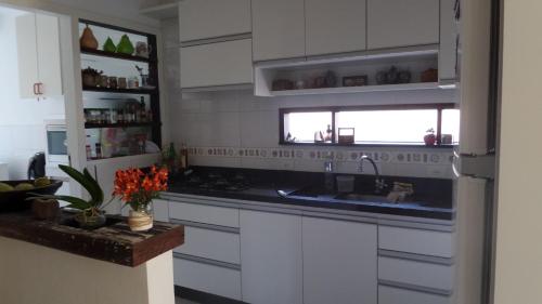 a kitchen with white cabinets and a sink and a window at Casas Adilio Florianopolis-norte in Florianópolis