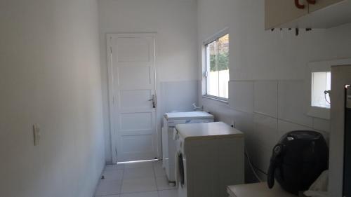a white bathroom with a sink and a washing machine at Casas Adilio Florianopolis-norte in Florianópolis