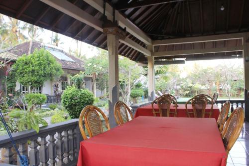 a red table and chairs on a porch at Taman Lily's Hotel in Lovina