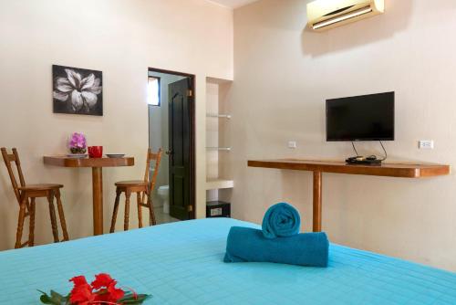 a bedroom with a bed with a blue pillow on it at Playa Negra Surf Lodge in Playa Negra