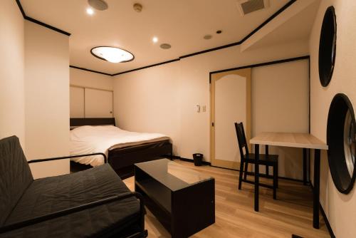 a room with a bed and a couch and a table at Tokyo Guest House Ouji Music Lounge in Tokyo