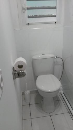 a white bathroom with a toilet and a window at Le Rêve Bleu in Dumbéa