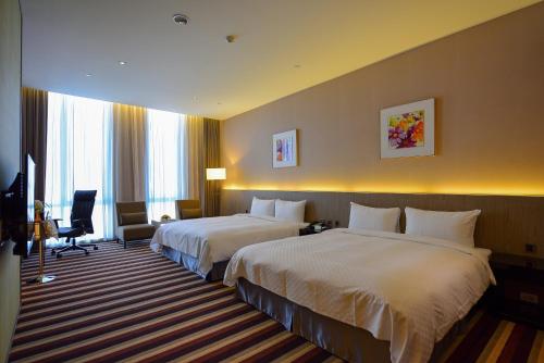 a hotel room with two beds and a television at Grand Royal Hotel in Toufen