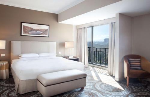 une chambre d'hôtel avec un lit et une grande fenêtre dans l'établissement Hyatt Regency Bishkek, à Bishkek