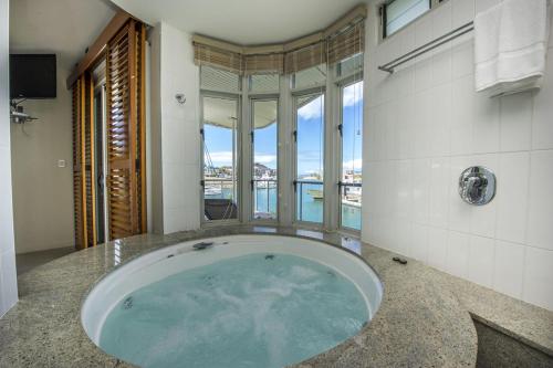 a large tub in a bathroom with a view of the water at Waters Edge Townhouse 2 in Nelly Bay