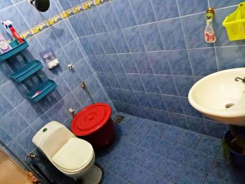 a bathroom with a red toilet and a sink at Farzai Homestay in Lumut