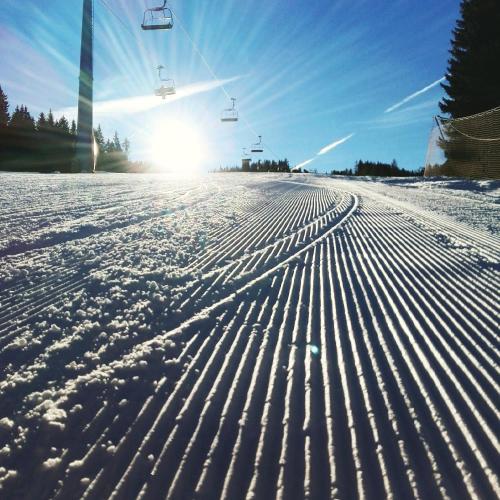 a snow covered ski slope with a ski lift at MOOKI Country Apartment in Villach