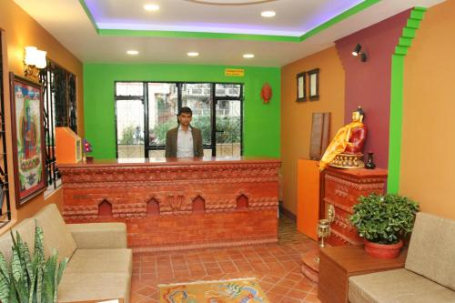 a man standing at a bar in a room with green walls at Thamel Backpackers Home in Kathmandu