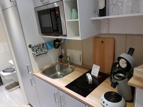 una pequeña cocina con fregadero y microondas en Ferienwohnung Oliver, en Fritzlar