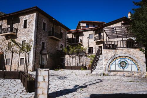 a large stone building with a clock on it's side at Trikolonion Country Stemnitsa in Stemnitsa