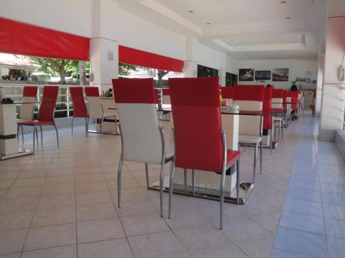 a restaurant with red and white chairs and tables at Jomtien View Talay Studio Apartments in Jomtien Beach