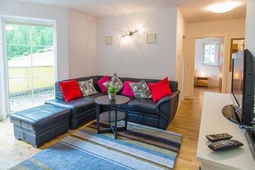 a living room with a black leather couch and a table at Residenz Zwieselstein App.11 in Sölden