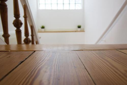 a wooden floor in a room with a window and stairs at Pfannkuchenhaus Fehmarn in Burg auf Fehmarn