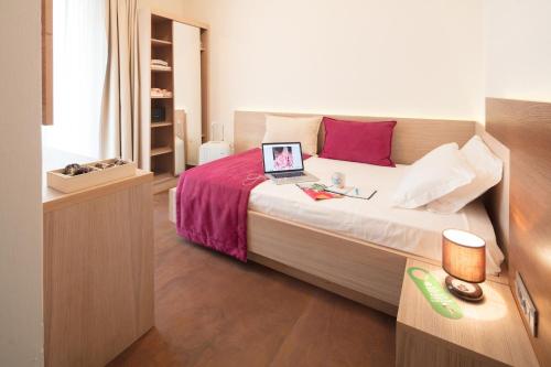 a bedroom with a bed with a laptop on it at Hotel Adria in Lignano Sabbiadoro
