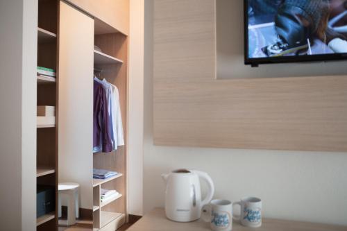a room with a tv and some cups on the floor at Hotel Adria in Lignano Sabbiadoro