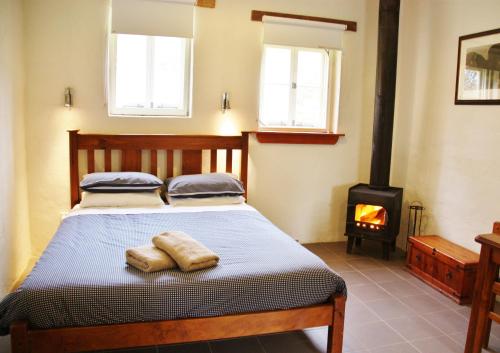 1 dormitorio con 1 cama y estufa de leña en Bungaree Station, en Clare