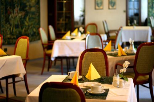 a dining room with tables and chairs with yellow napkins at Hotel Zur Heidquelle in Blumenthal