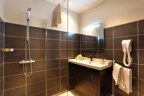 y baño con lavabo y ducha. en Hôtel Le Roncevaux, en Pau