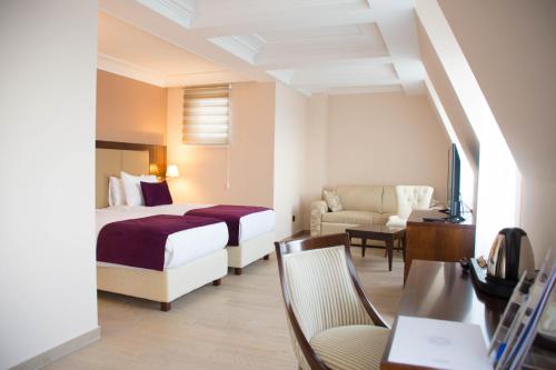 ベオグラードにあるXenon Hotel & SPAのベッドと椅子付きのホテルルーム