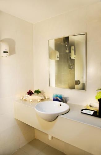 a white bathroom with a sink and a mirror at Hotel Langkasuka Langkawi in Kuah