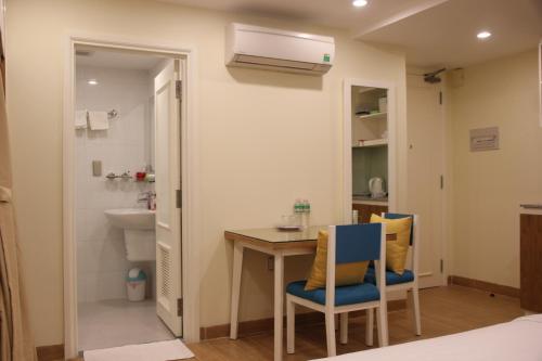 une petite cuisine avec une table et deux chaises dans l'établissement BX Apartment, à Nha Trang
