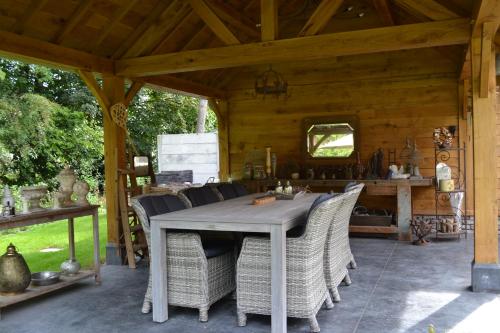 a dining table and chairs under a wooden pavilion at B&B 't Heirweggoed in Assenede