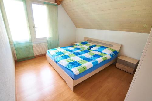 Dormitorio pequeño con cama en el ático en New West Station 7, en Interlaken