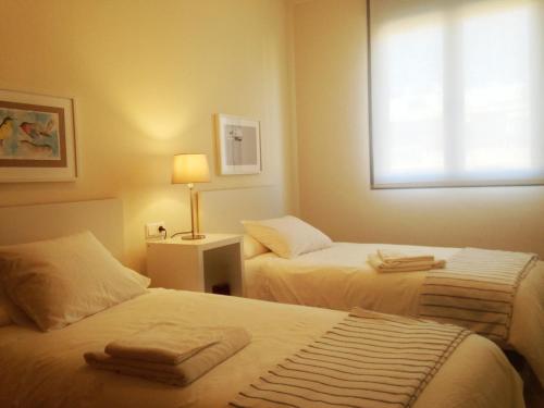 Cette chambre comprend 2 lits et une fenêtre. dans l'établissement Apartamento Ollerías, 31, à Cordoue