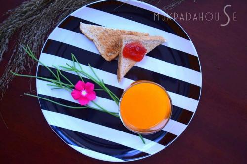 een bord met twee sneetjes toast en een glas sap bij Mukrada House Boutique Hometel Krabi in Klong Muang Beach