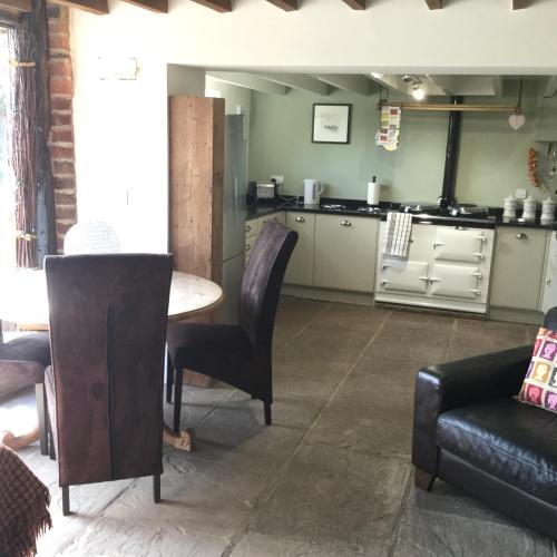 a living room with a table and a kitchen at Crossgate Farm in Cattal
