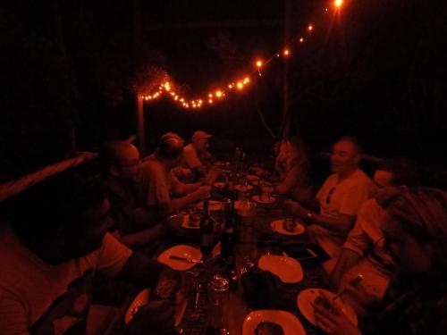 a group of people sitting around a long table in the dark at Fish Eagle Point in Subutuni