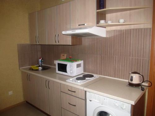 uma pequena cozinha com fogão e micro-ondas em Apartment on Hoholya 90 em Kropyvnytskyi