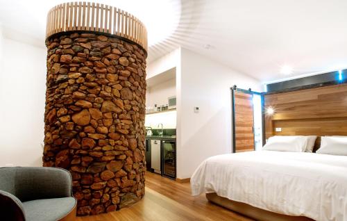 a bedroom with a bed and a stone pillar at The Cellars At Heathcote II in Toolleen