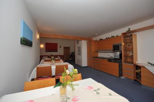 a room with a kitchen and a dining room with a table at Wellness Pension Waldhof in Sankt Georgen