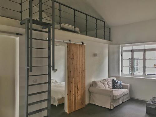 アングラ・ド・エロイーズモにあるCasa do Pisão - Cosy and Modern Two-Bedroom Townhouseのロフトベッド1台(ハシゴ付)