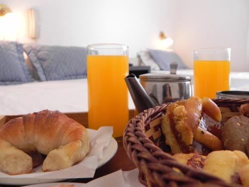 a table with a basket of bread and orange juice at Gran Hotel Manila in Mar del Plata
