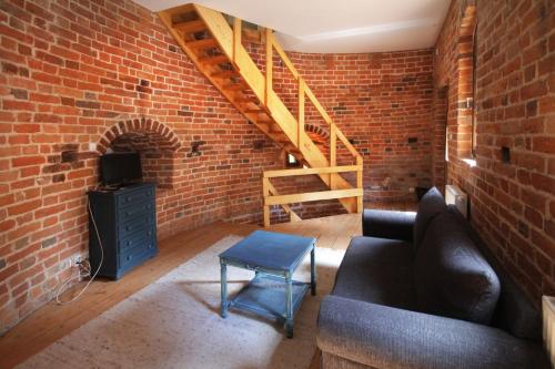 a living room with a couch and a brick wall at Zamek Reszel in Reszel