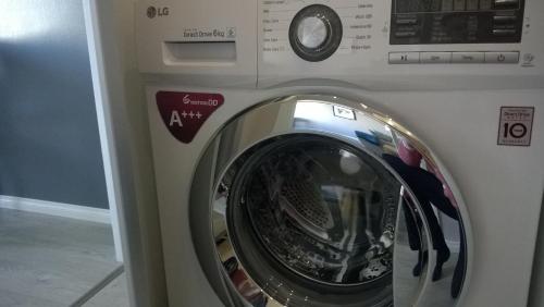 a washing machine with its door open in a room at Piriko Studio Apartments in Rovaniemi